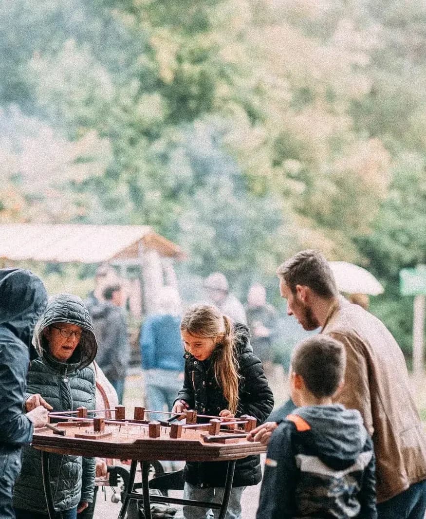 Kinderen en ouders rond de achthoekige tafel van het hamerspel