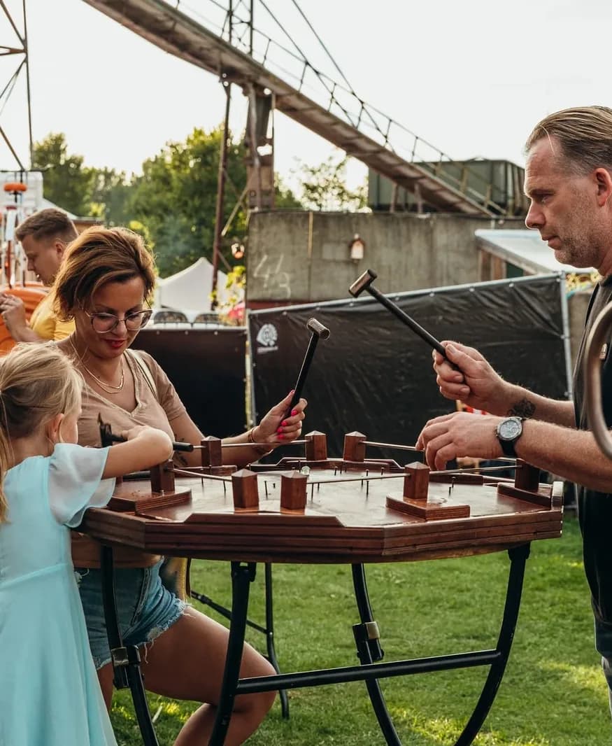 Vrouw en meisje met hamers aan de tafel van het hamerspel